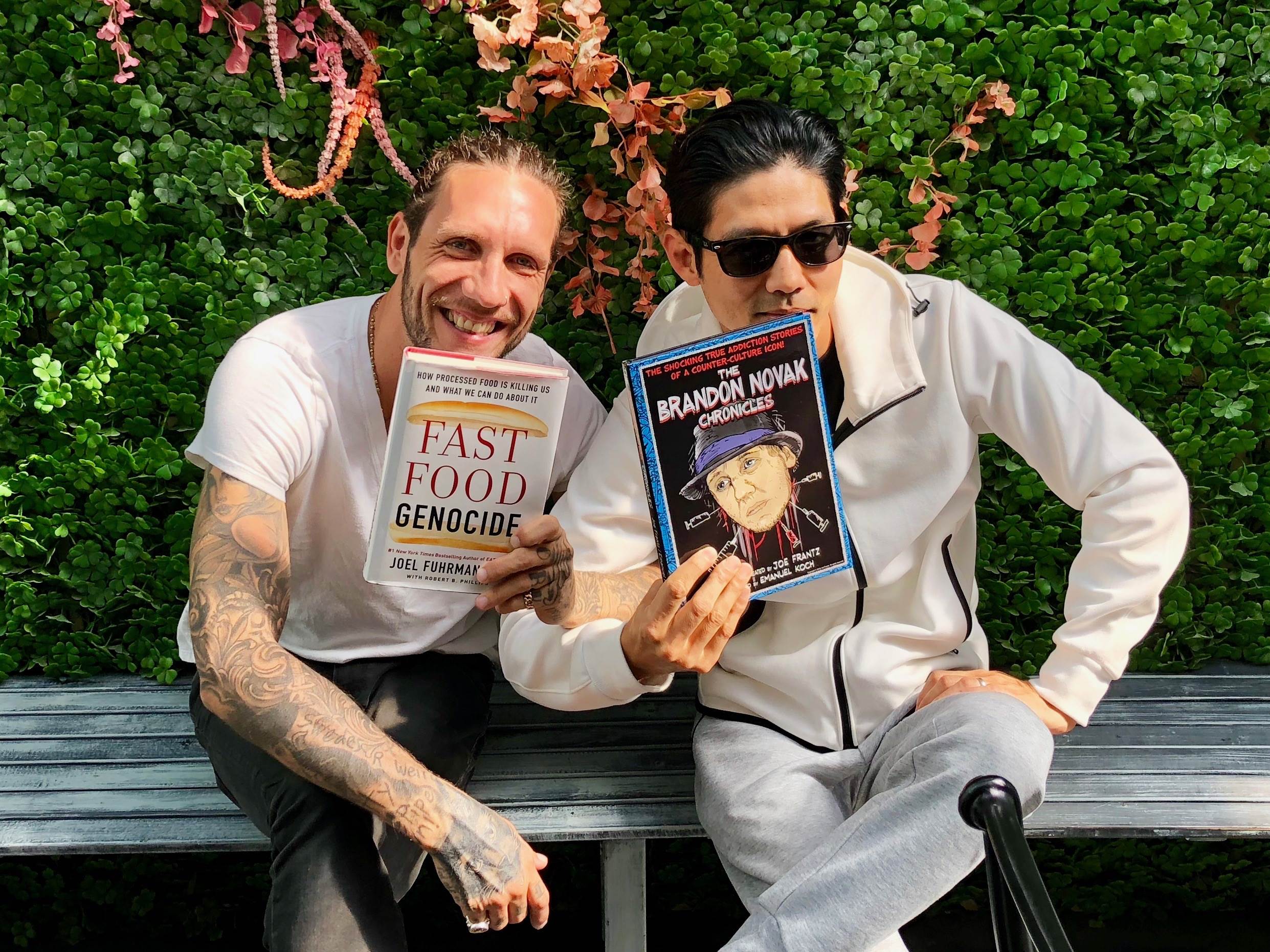 Brandon Novak and Dr Yi enjoying their new favorite books - Fast Food Genocide from fellow New York Times Best Selling Author Joel Fuhrman, MD and The Brandon Novak Chronicles